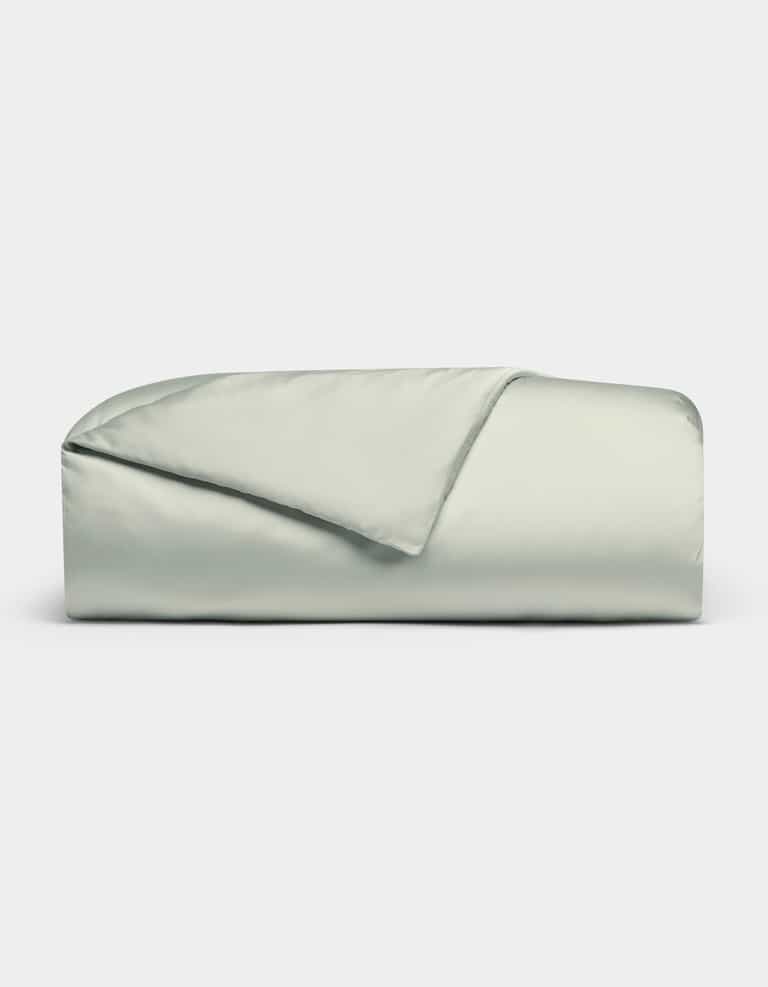 A neatly folded Bamboo Duvet Cover by Cozy Earth in light gray or pale green, with one corner flipped to reveal the interior, set against a plain white background.|Color:Laurel