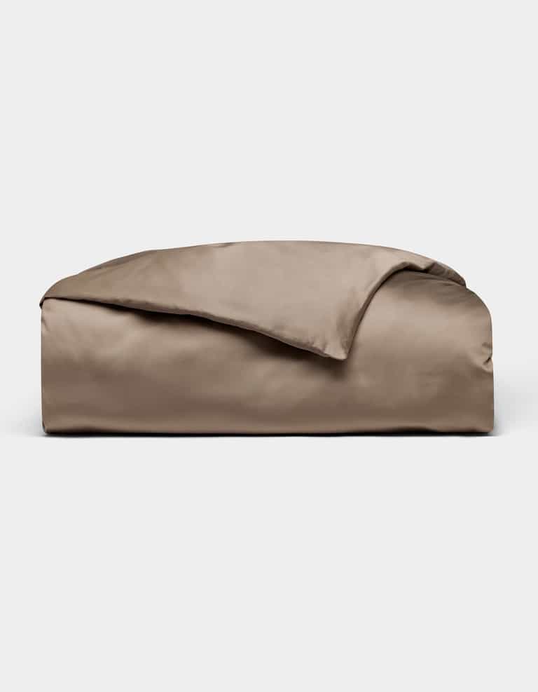 The Cozy Earth Bamboo Duvet Cover in taupe is neatly folded with one corner flipped over, displayed against a plain light grey background.|Color:Walnut