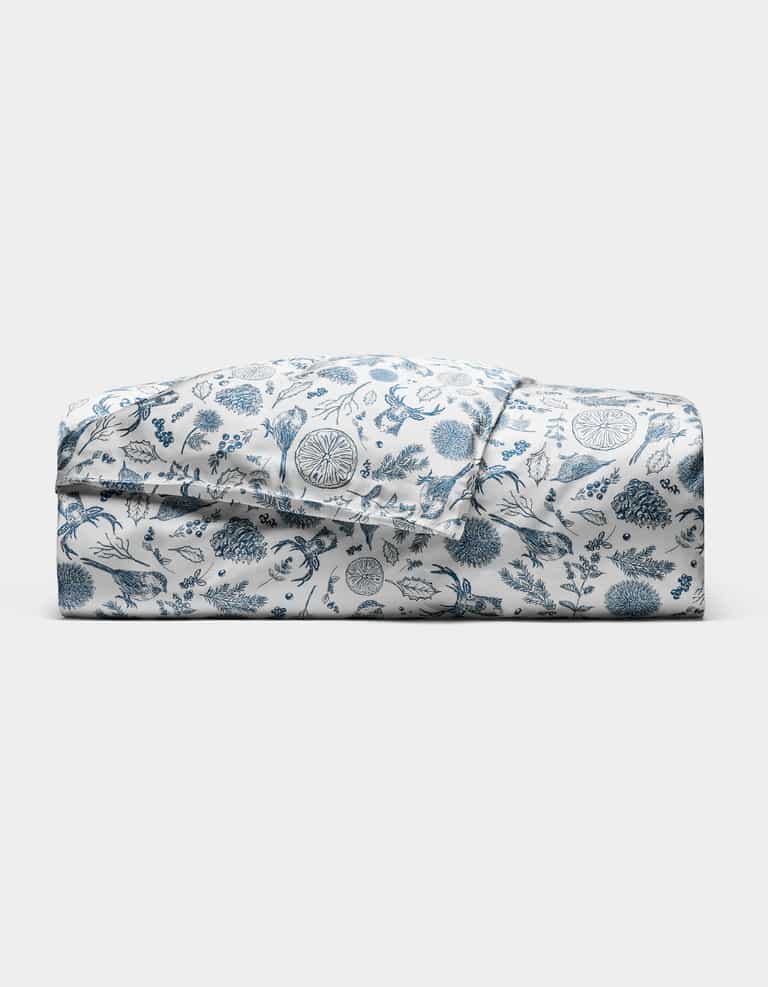 The Cozy Earth Bamboo Duvet Cover features a blue floral and botanical print on white, neatly folded and displayed against a plain white background.|Color:Winter Toile Pacific