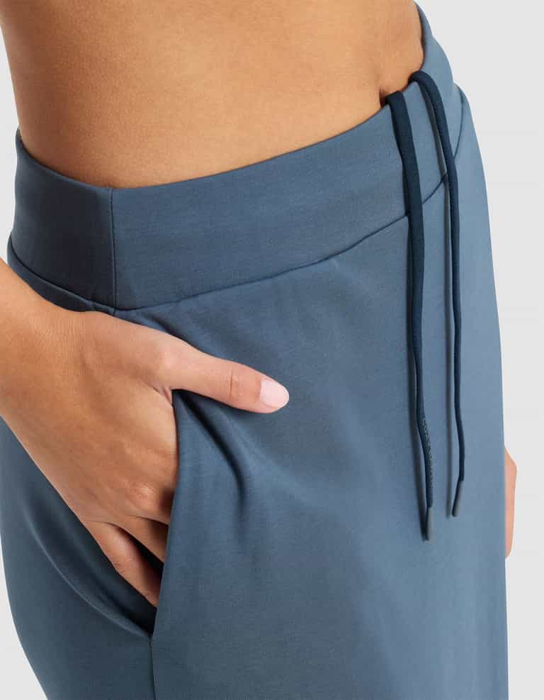 Close-up of a person’s hand in the pocket of the Cozy Earth Women’s Brushed Bamboo Midi Skirt, showing part of the waist and hip against a light background.|Color:Dawn