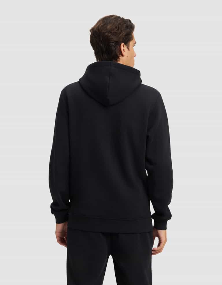 A person with short brown hair faces away, wearing the Cozy Earth Men's Cityscape 2.0 Hoodie and matching black pants against a plain light gray background.|Color:Jet Black