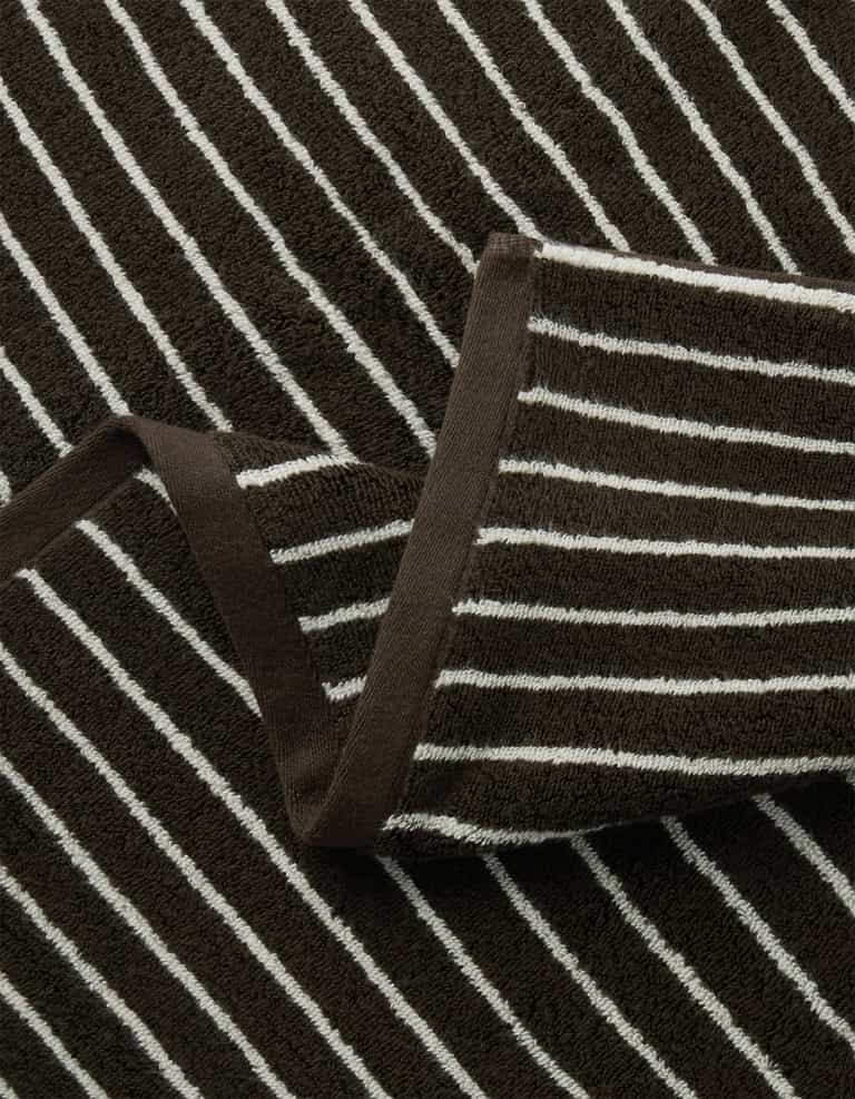 Close-up of the Cozy Earth Complete Striped Luxe Bath Bundle, featuring brown terry cloth with white horizontal stripes, a folded section, and brown trim along the edge.|Color:Espresso Coconut Stripe
