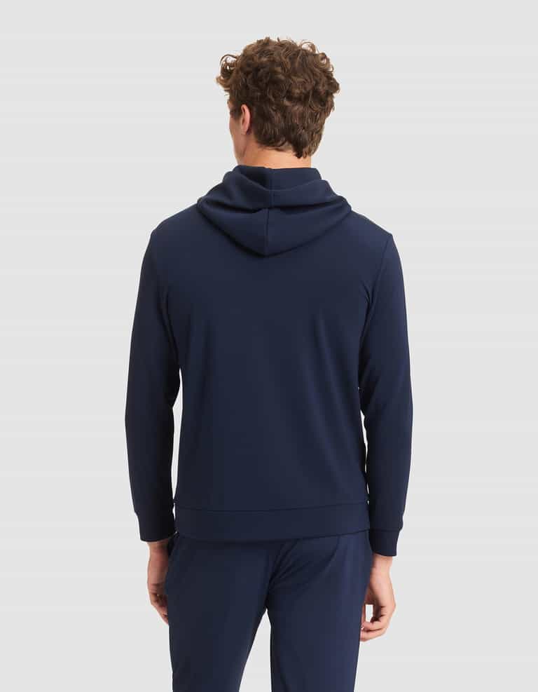 A person with curly brown hair is shown from behind, wearing the Cozy Earth Men's Brushed Bamboo Hoodie in navy and matching pants against a plain light gray background. |Color:Navy