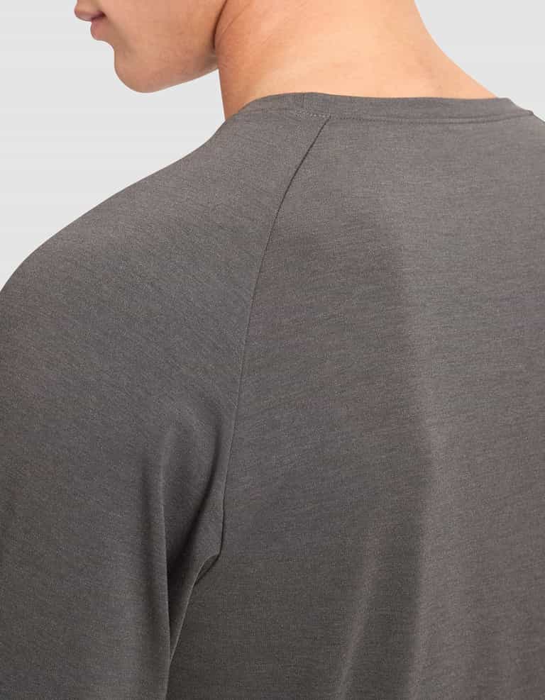 Close-up of a person wearing the Cozy Earth Men's Brushed Bamboo Pullover Crew in dark gray, showing the upper back, shoulder, and part of the neck and jawline against a plain light background. |Color:Charcoal