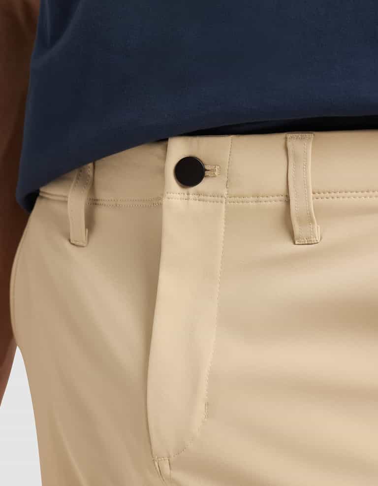 Close-up of a person wearing Cozy Earth Men's Everywhere Pant in beige with black button and belt loops, paired with a tucked-in navy blue shirt. |Color:Khaki