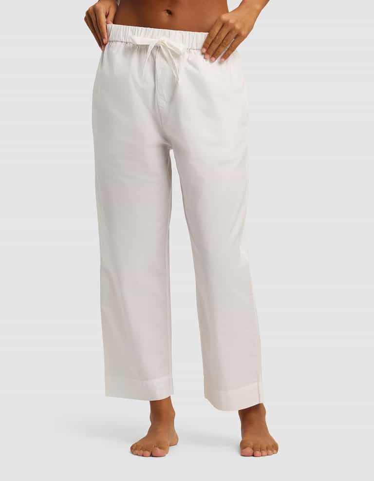A person stands barefoot, wearing Cozy Earth's Women's Sutton Cropped Pajama Pant. Only the lower torso and legs are visible against a plain light background.|Color:White