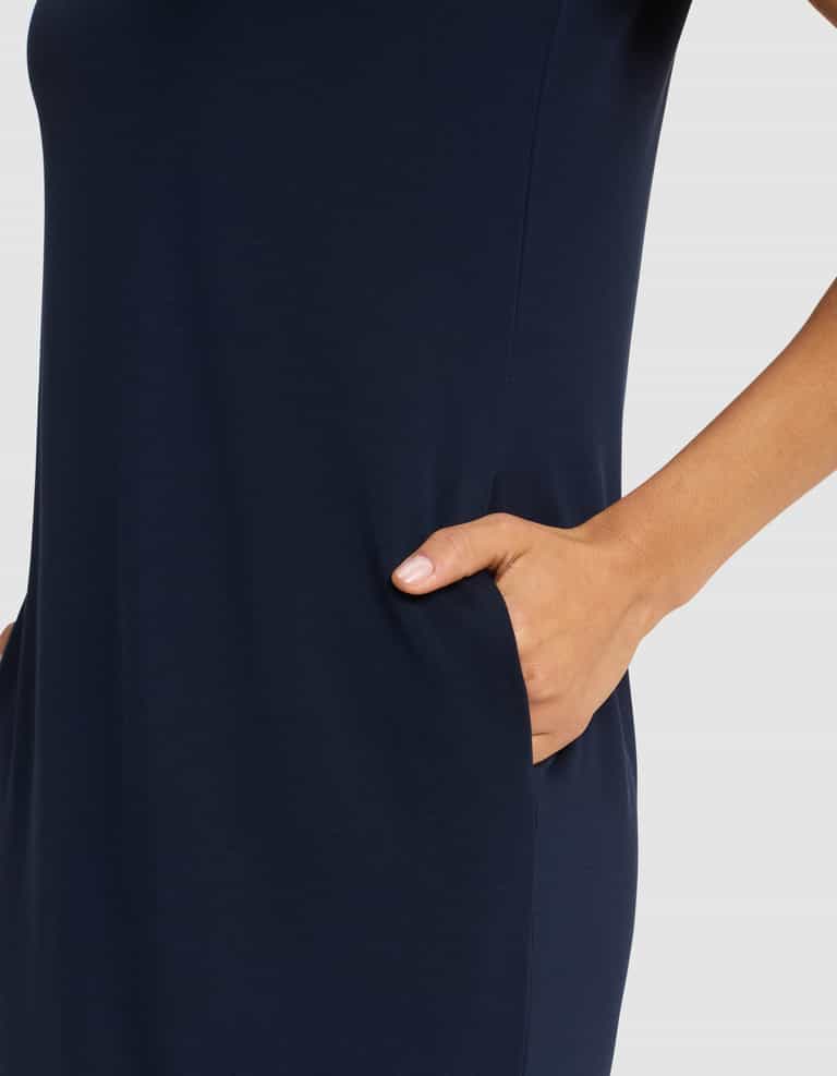A woman models the Cozy Earth Women's Brushed Bamboo Midi Dress in dark blue, shown from shoulder to mid-thigh with her right hand in a side pocket, set against a plain light background.|Color:Navy