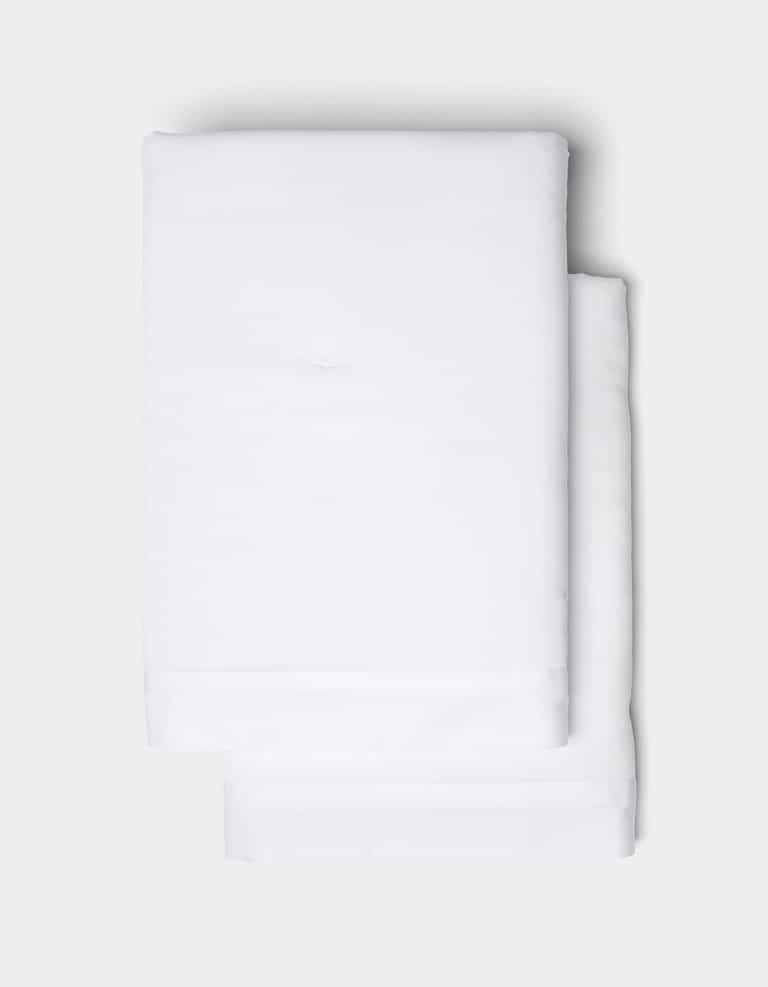 Two Soft-Wash Cotton Quilted Shams by Cozy Earth, neatly folded and stacked atop each other, set against a light gray background.|Color:White