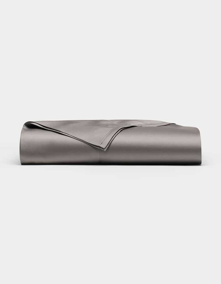 A neatly folded, smooth Cozy Earth Bamboo Flat Sheet in grey is displayed against a plain white background.|Color:Charcoal