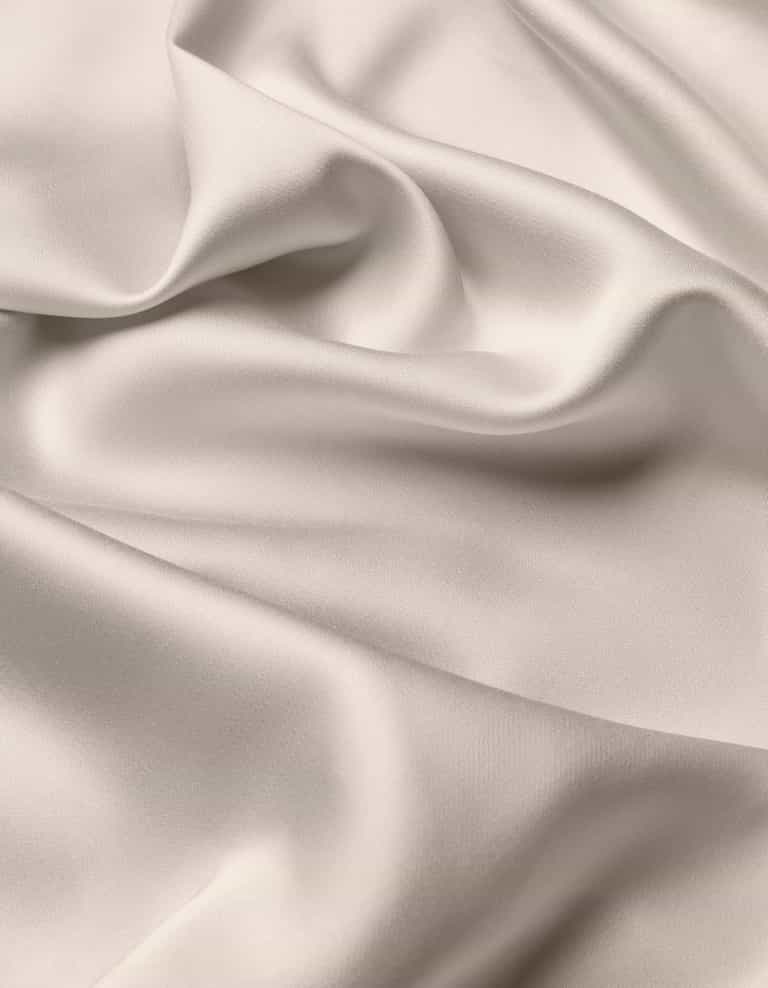 The Cozy Earth Bamboo Flat Sheet features a smooth, light-colored fabric with soft folds and gentle draping, creating a silky, elegant texture.|Color:Driftwood