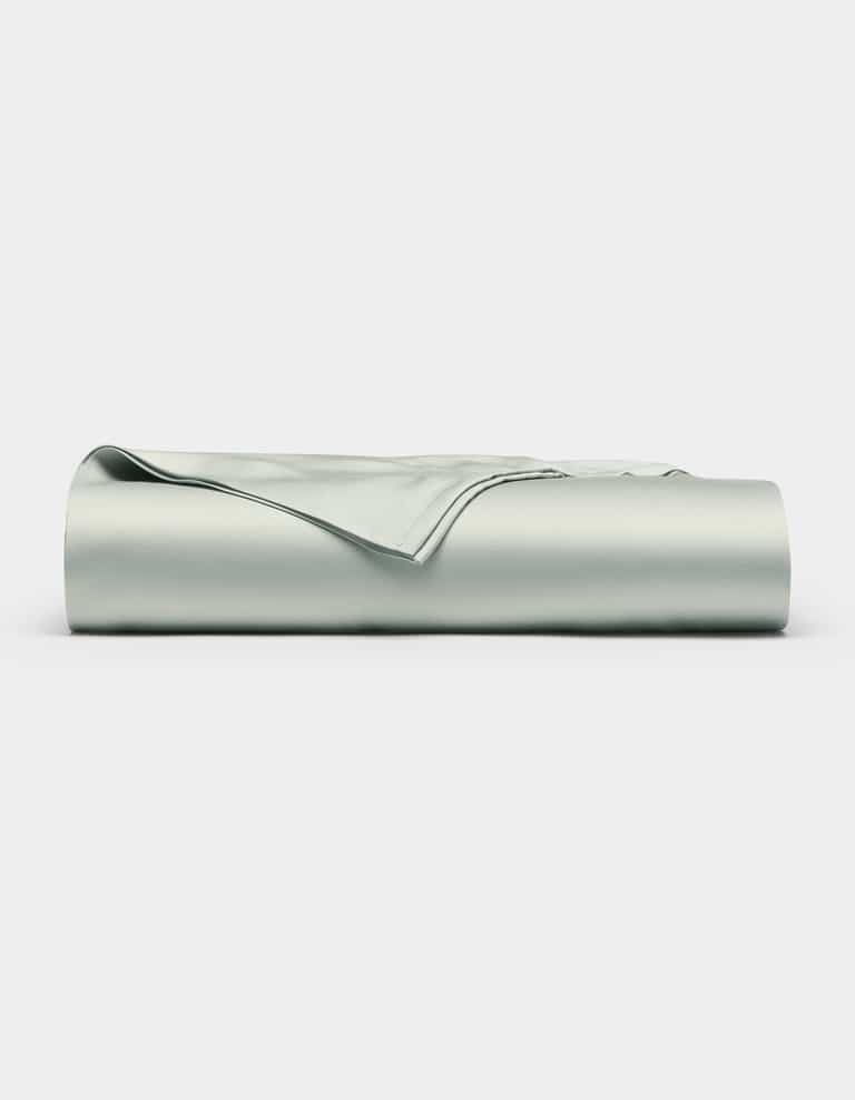 A neatly folded Bamboo Flat Sheet by Cozy Earth in light gray is displayed against a plain white background.|Color:Laurel