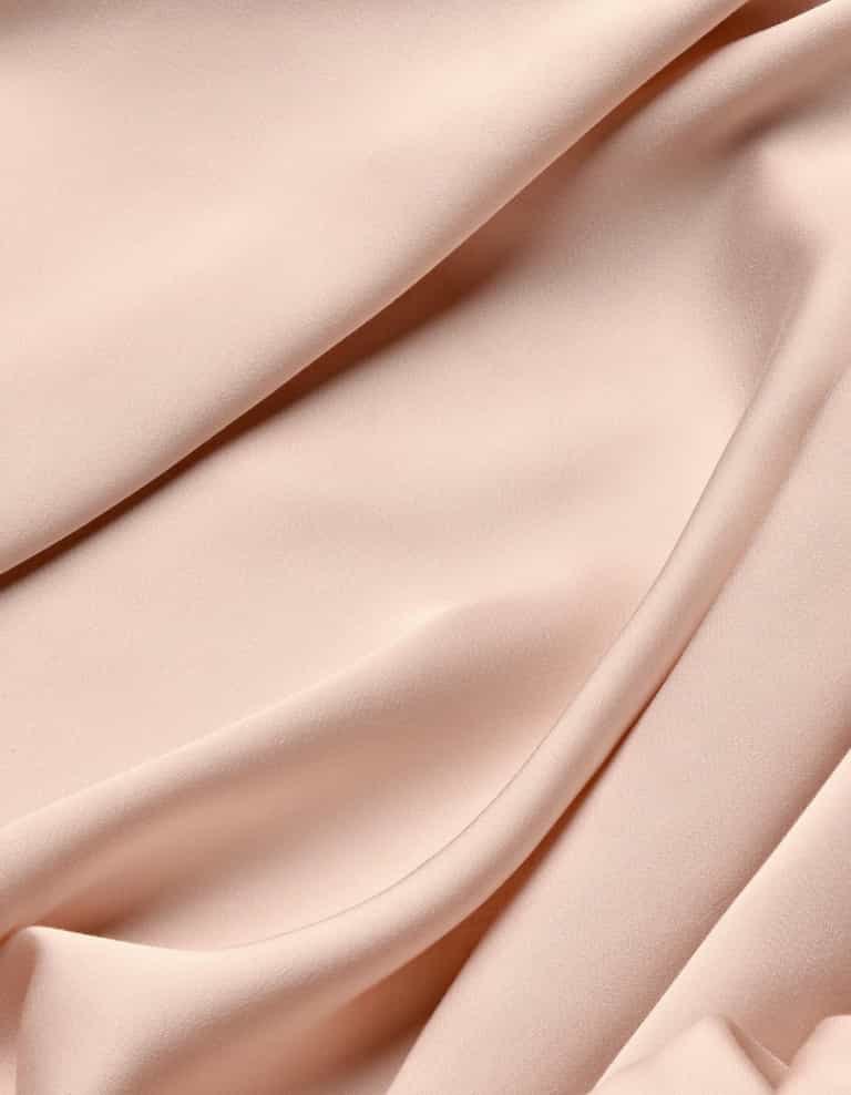 The Cozy Earth Bamboo Flat Sheet features soft, light pink fabric with a matte finish, gently draping to create smooth, flowing folds and elegant curves across your bed.|Color:Peony