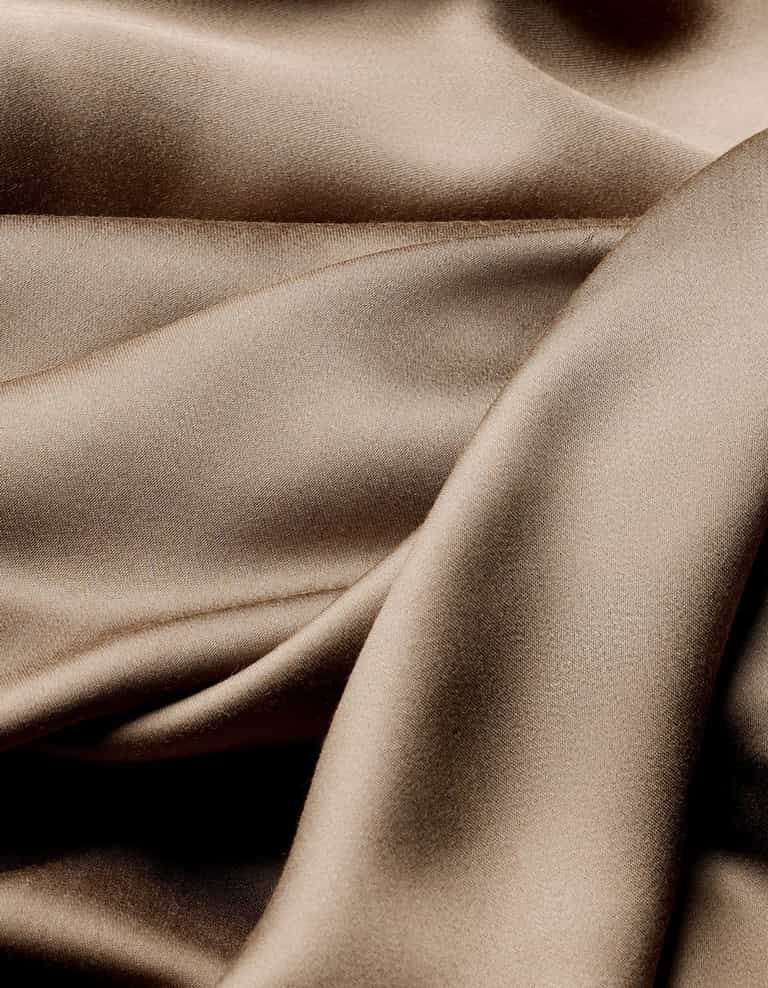 The Cozy Earth Bamboo Flat Sheet features smooth, light brown satin fabric with soft folds and gentle curves for a shimmering, luxurious texture.|Color:Walnut